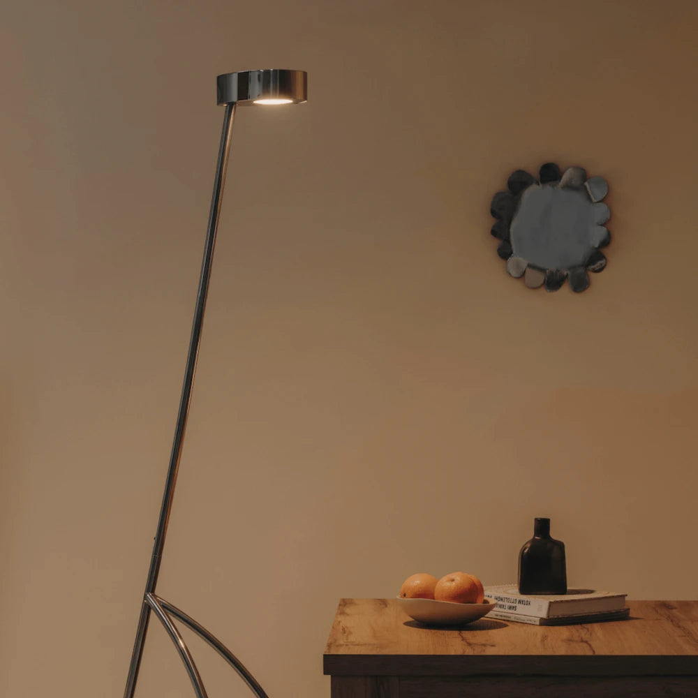 The Giraffe Lamp standing tall in a modern living room, casting a warm and inviting glow