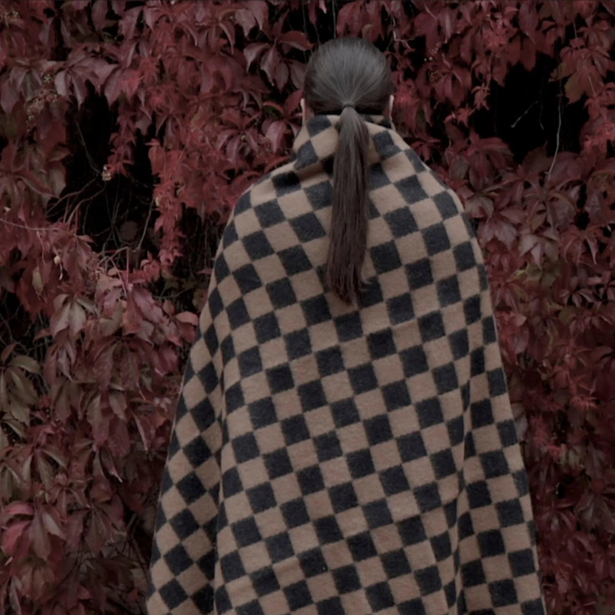  Person snuggled up with the Arkiivi Throw while reading a book in a cozy nook